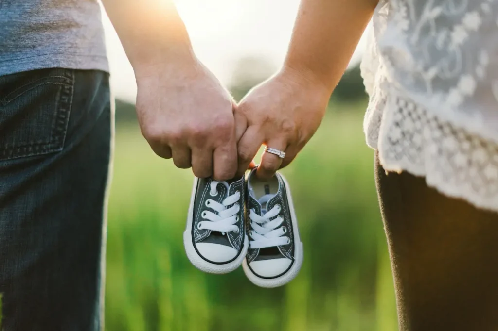 Woman and Man Holding Black Crib Shoes