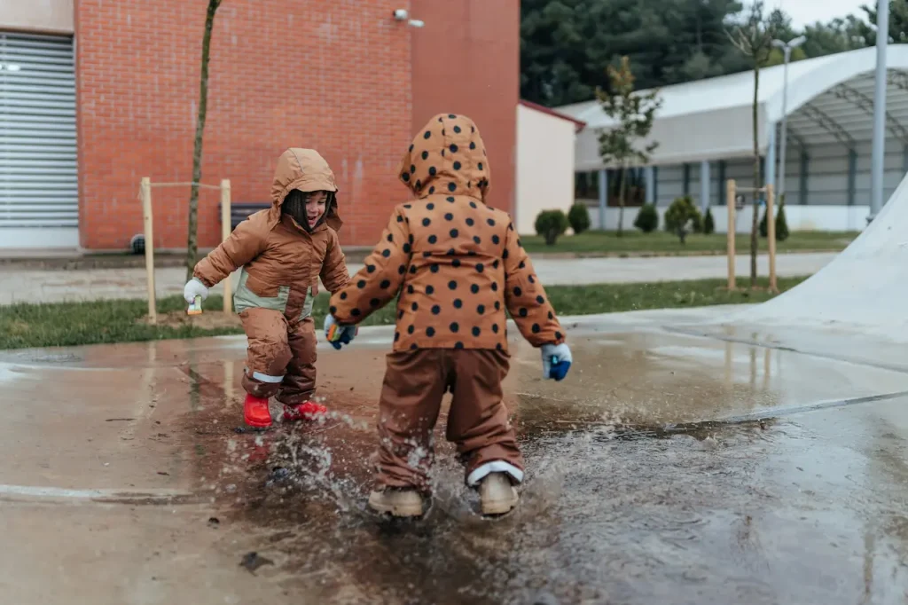 Boys Wearing Raincoat Playing in the Water 