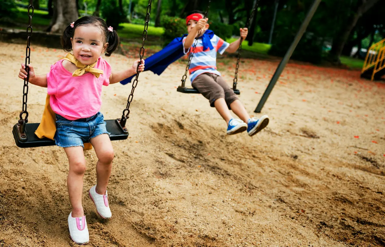 Children Playing in the Swing at the Playground